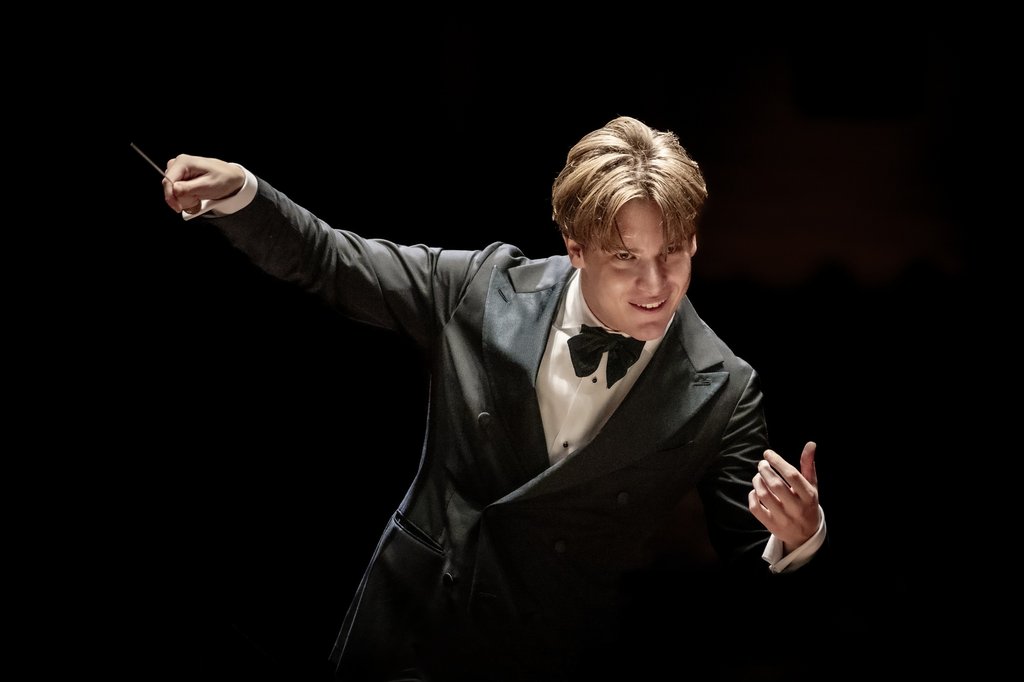 Klaus Mäkelä dirigeert en kijkt orkest aan.